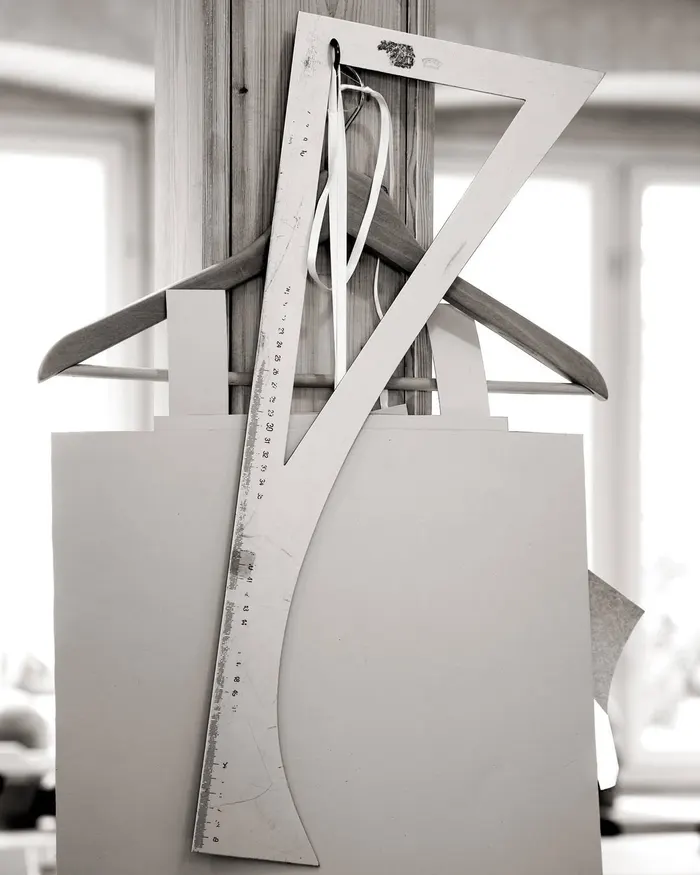 Cutting square, cardboard patterns and a wooden hanger in the atelier
